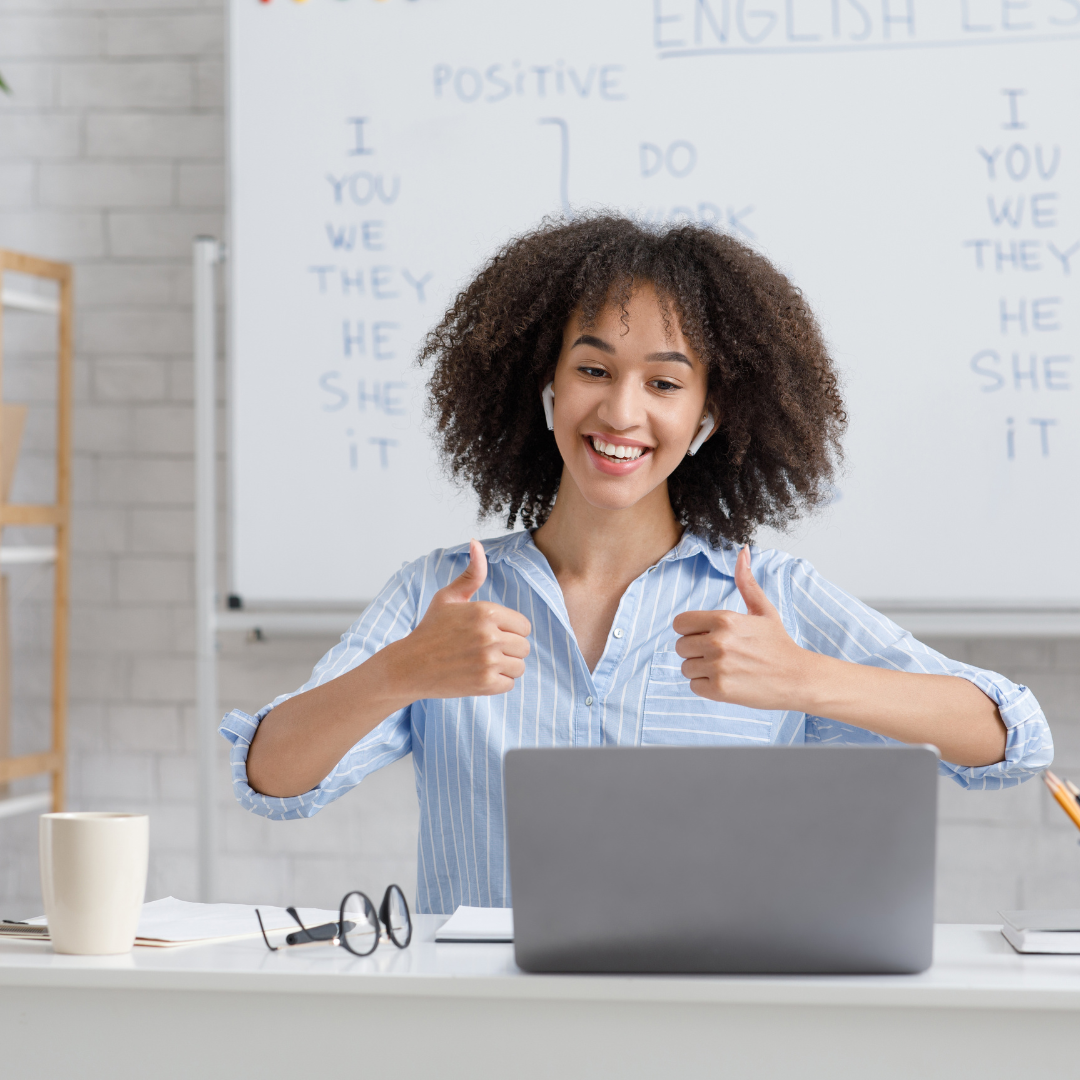 Academic on her laptop having a video call with her thumbs up