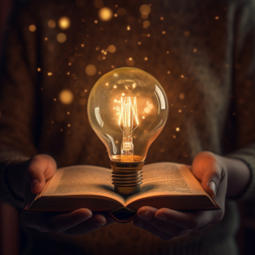 Image of an open book with a lit light bulb in the centre