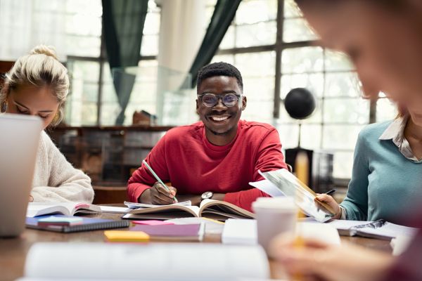 Image of man sat at desk studying smiling at the camera