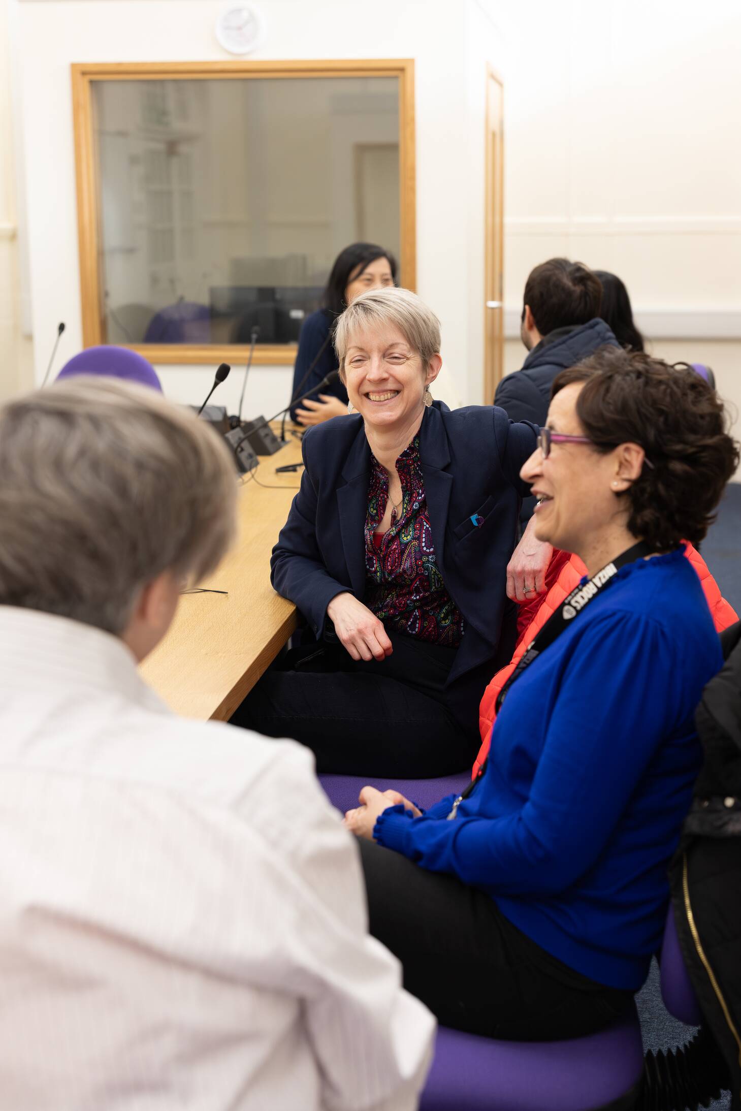 Image shows staff smiling at a table.