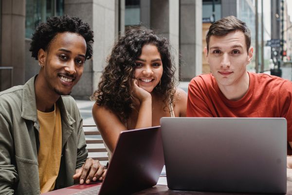 image of three students sat looking at laptops