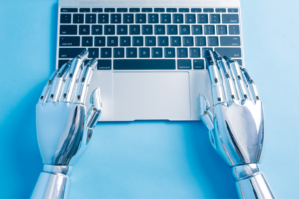 image of pair of robot hands typing on a laptop