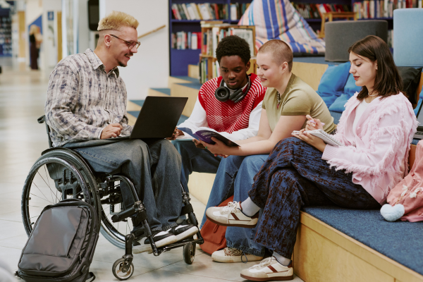 image of student in wheelchair with three other students sat learning