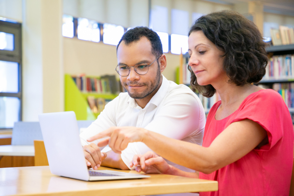 image of two people sat round a laptop