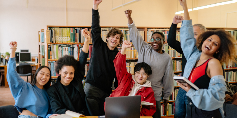 group of students in a library setting cheering