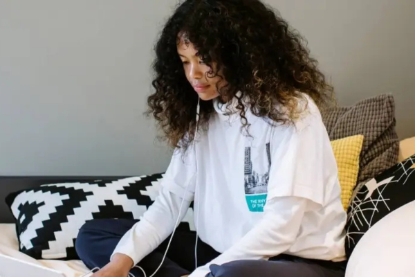 Image of student sat on bed listening to music