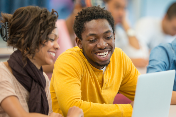 Image of two students on laptop