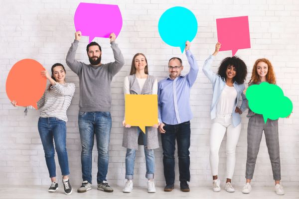 Image of people stood holding up speech bubbles