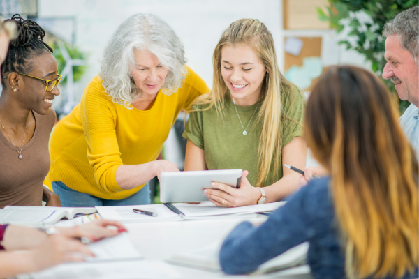 Image of academic and groupf of students looking at a tablet