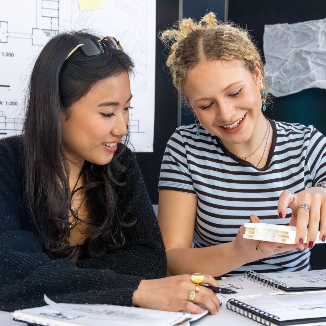 Image shows two MA Architecture students reviewing work