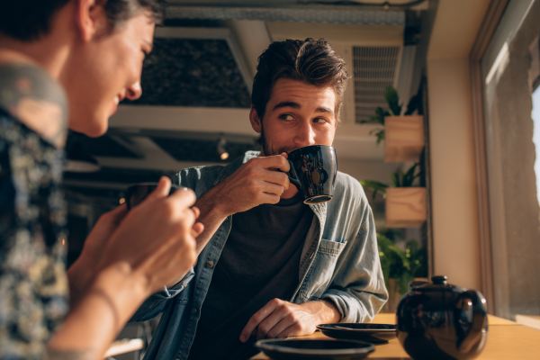 man drinking coffee, sat with woman