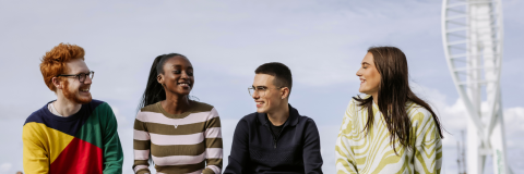 Image of students sat in front of spinnaker tower